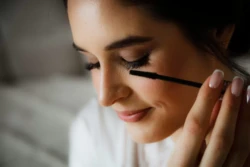 Naturalny makijaż na wesele Naturalna panna młoda poprawia swój makijaż przed ślubem.