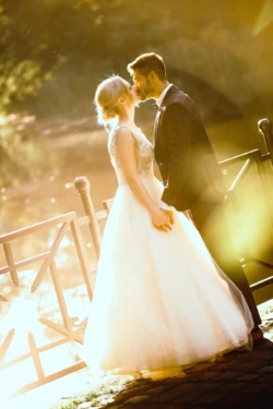 Najlepsze plenery ślubne Romantyczny pocałunek młodej pary. Złota godzina i piękne światło podczas sesji plenerowej