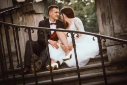 Sesja plenerowa Para młoda siedzi na schodach, wpatrzona w siebie. Sesja plenerowa w parku.